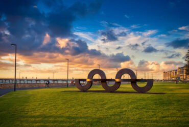 Adelaide, South Australia - February 25, 2016: Wave shaped installation in Jimmy Melrose Park at Glenelg viewed towards jetty at sunset